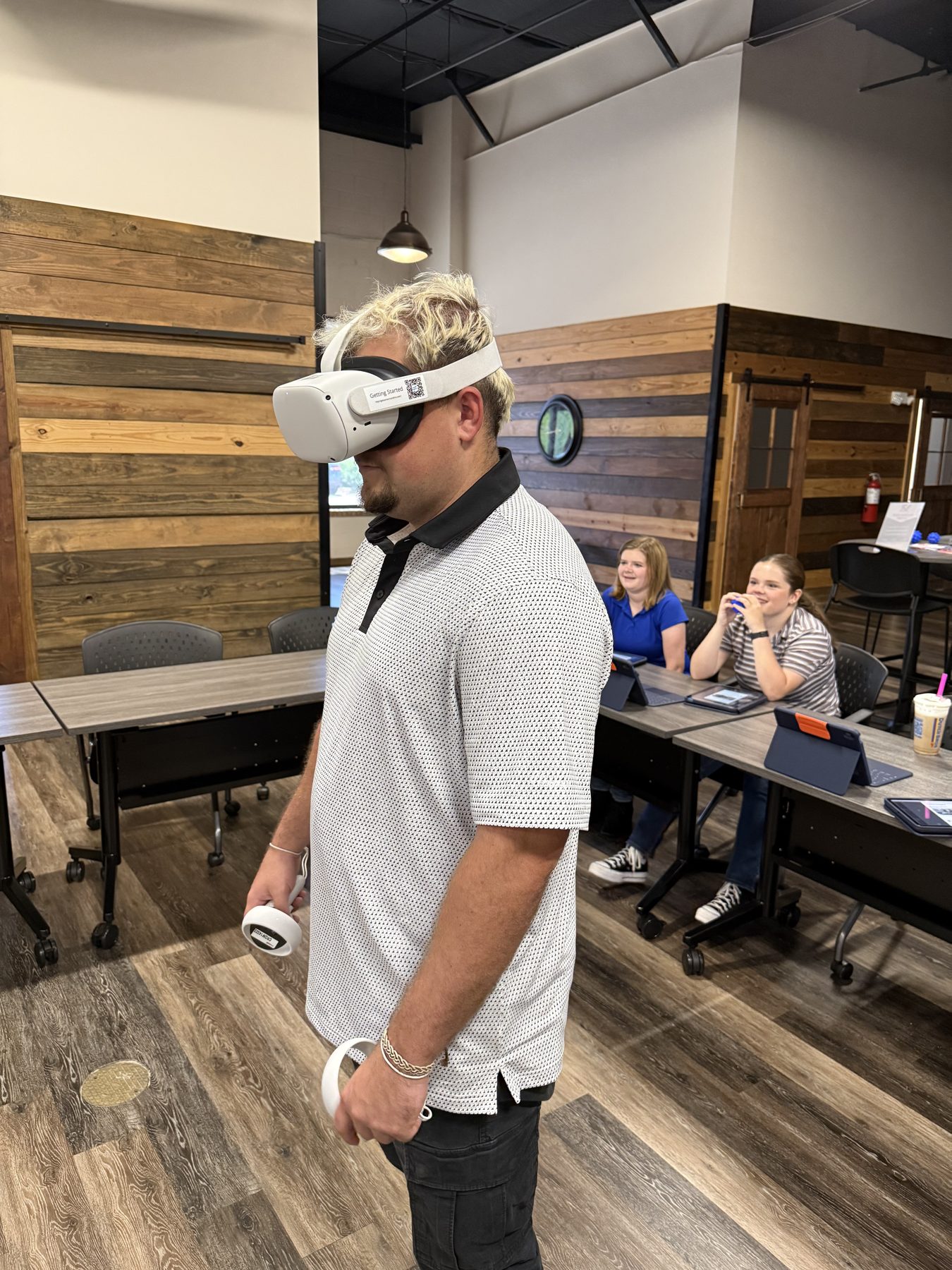 A young participant trying out a career in virtual reality while others work in the background